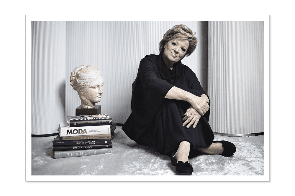 Annamaria Cammilli accanto a dei libri di formazione e una scultura